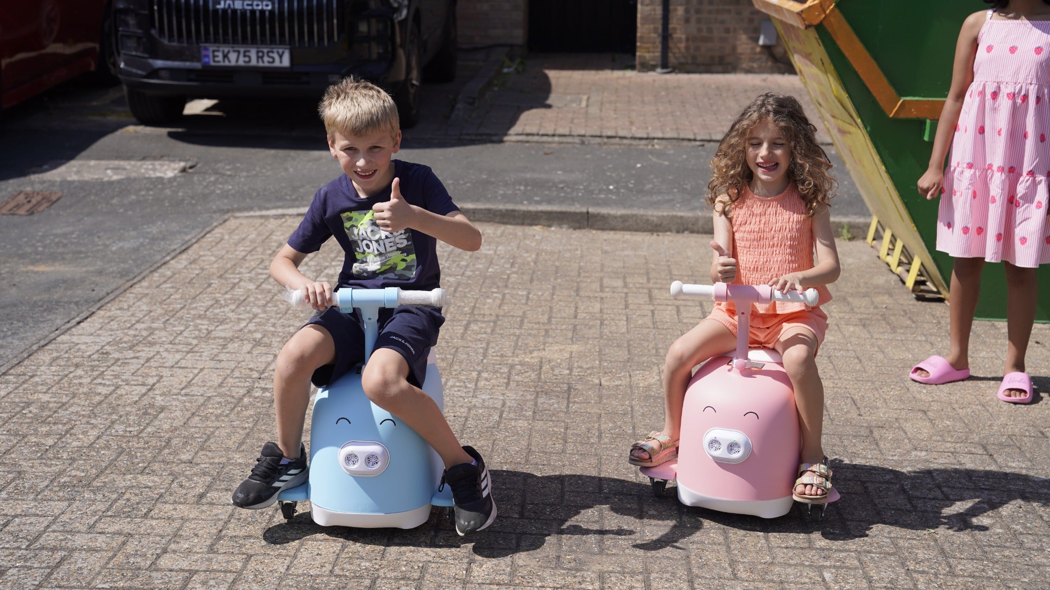 Children enjoying pink and blue Piggy ride-ons